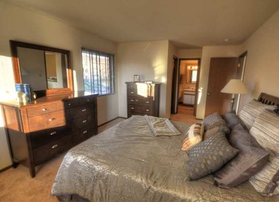 a bedroom with a bed and a dresser and a mirror