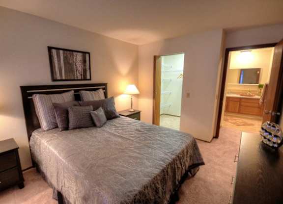 a bedroom with a large bed and a bathroom