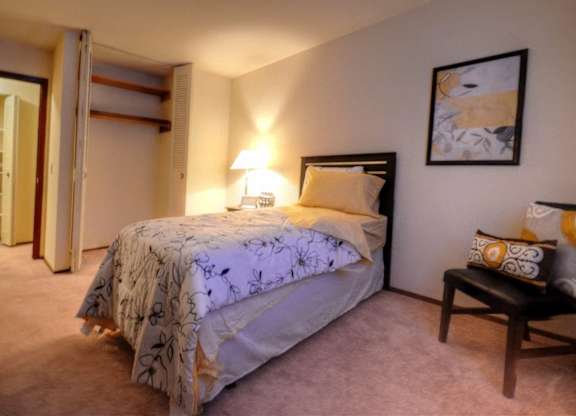 a bedroom with a bed and a chair and a closet