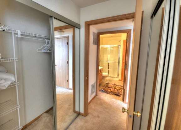 a bathroom with a closet and a mirror in a closet