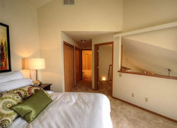 a bedroom with a bed and a hallway to a bathroom