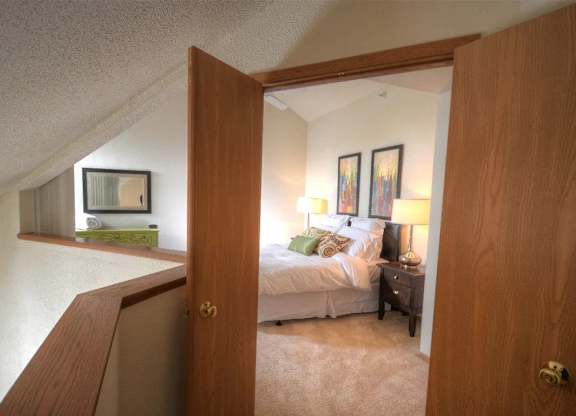 a bedroom with a bed and a mirror in a room