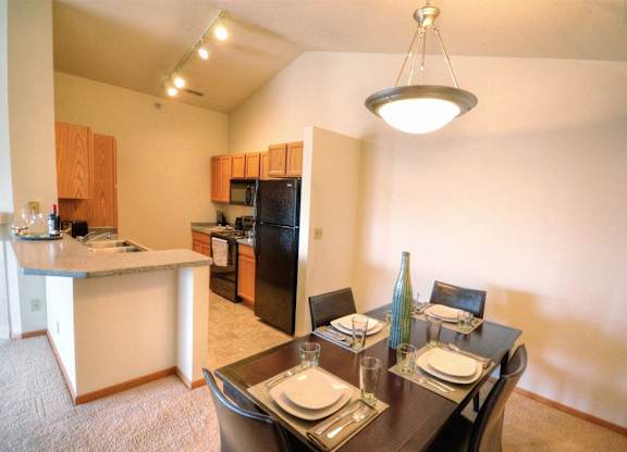 a dining room and kitchen with a table and chairs