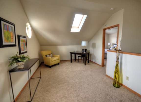 a living room with a couch and a table and a door to a dining room
