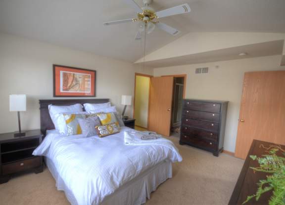 a bedroom with a large bed and a ceiling fan
