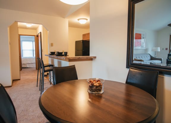 a dining room and kitchen with a table and chairs and a living room with a