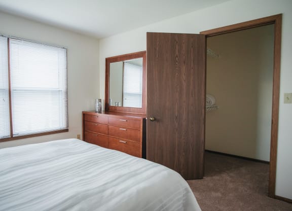 a bedroom with a bed and a closet with a mirror