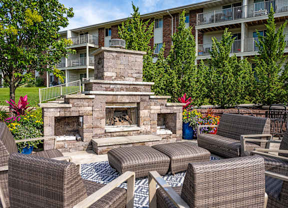 A patio with a fireplace and chairs.