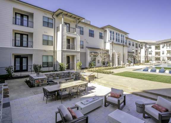 a group of apartments with a courtyard with tables and chairs