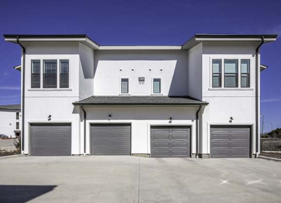 a white house with three garage doors