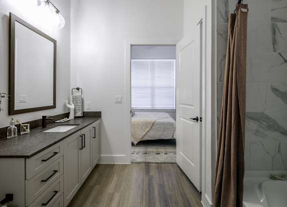 a bathroom with a shower and a sink and a mirror