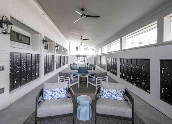 a lounge area with chairs and couches next to the mail lockers