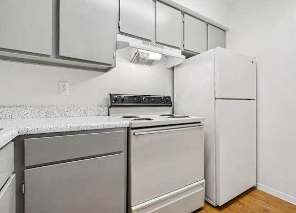 A kitchen with a white refrigerator and a stove top oven.