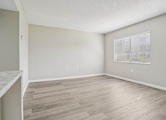 A room with a window and wooden flooring.
