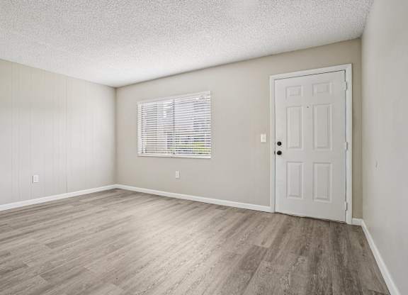 A room with a white door and a window with blinds.