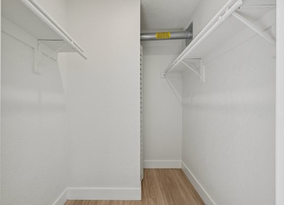 A white closet with a yellow sign on the shelf.