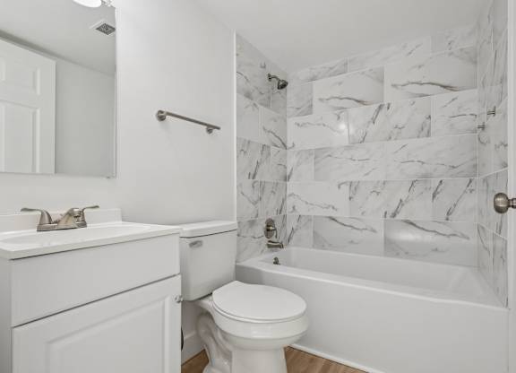 A white bathroom with a marble wallpaper.