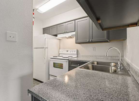 A kitchen with a granite countertop and stainless steel appliances.