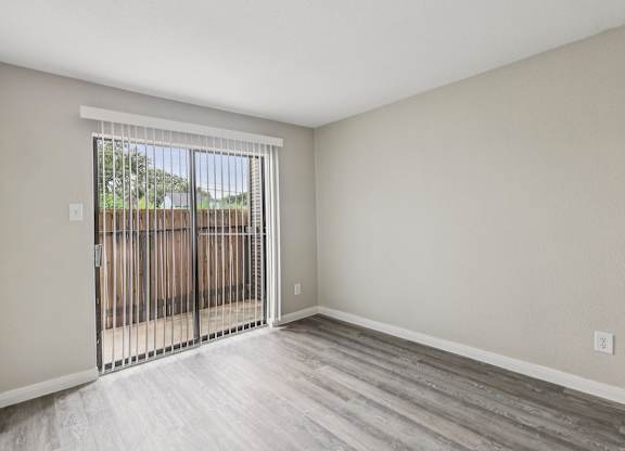 A room with a sliding door leading to a backyard.