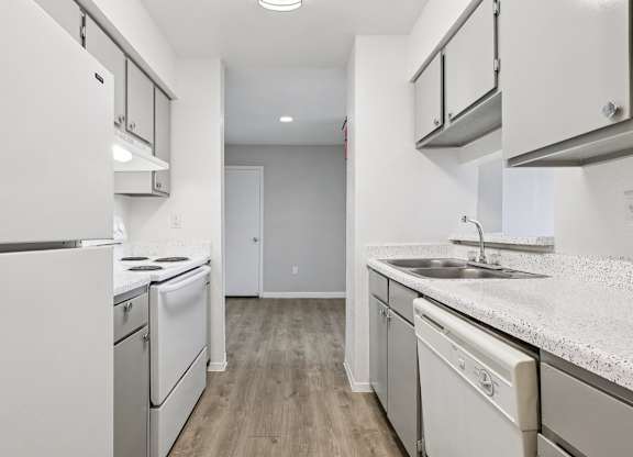 A kitchen with white appliances and cabinets.