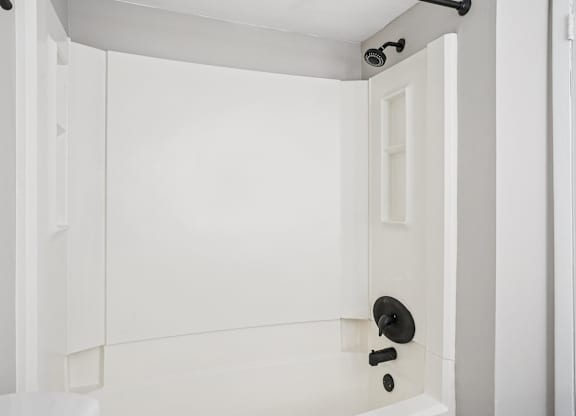 A white bathroom with a shower and a toilet.
