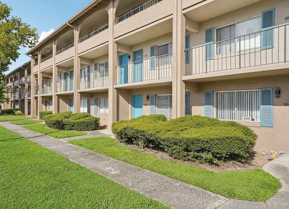 Apartment complex with green bushes in front.