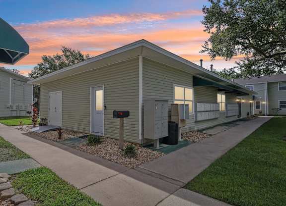A sunset view of a row of houses with a mailbox in the foreground.