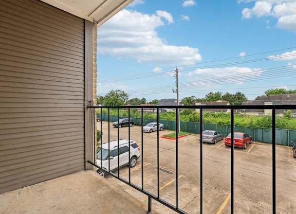 A parking lot with cars and a closed gate.