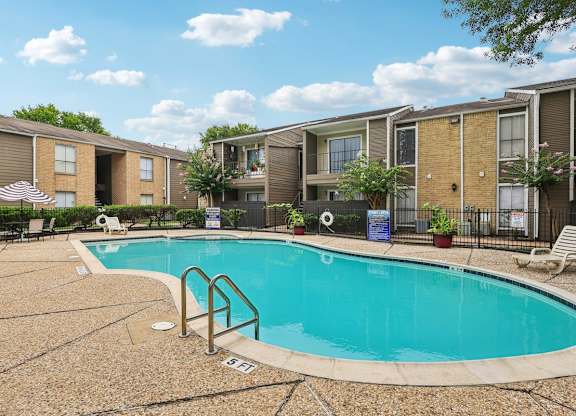 A swimming pool surrounded by apartment buildings.