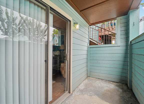 A room with a sliding glass door leading to a balcony.