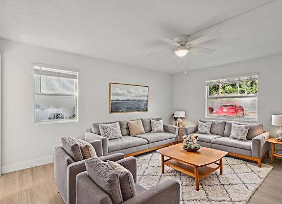 A living room with grey couches and a wooden coffee table.
