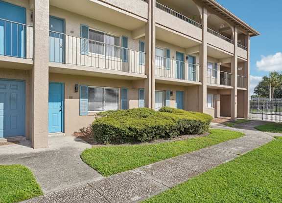A row of apartment buildings with blue doors and windows.