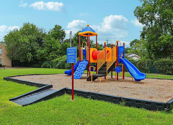 A playground with a blue slide and a yellow slide.