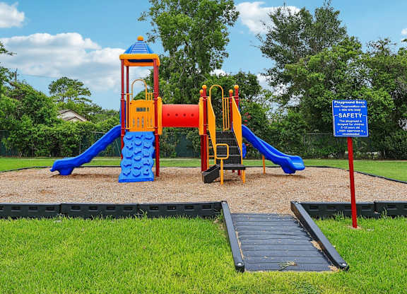 A playground with a blue slide and a yellow and red tower.