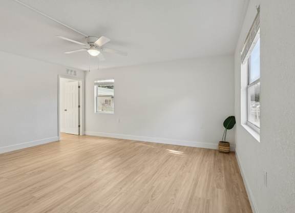 A room with a wooden floor and a ceiling fan.
