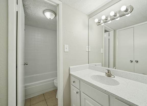 A bathroom with a white sink and a white toilet.