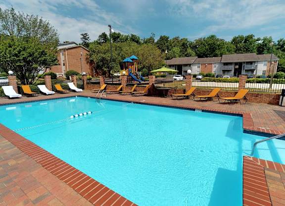 a swimming pool with orange lounge chairs around it at Ascot Place Apartments, Birmingham Alabama