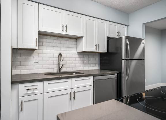 a kitchen with white cabinets and a stainless steel refrigerator at Ascot Place Apartments, Birmingham, 35235