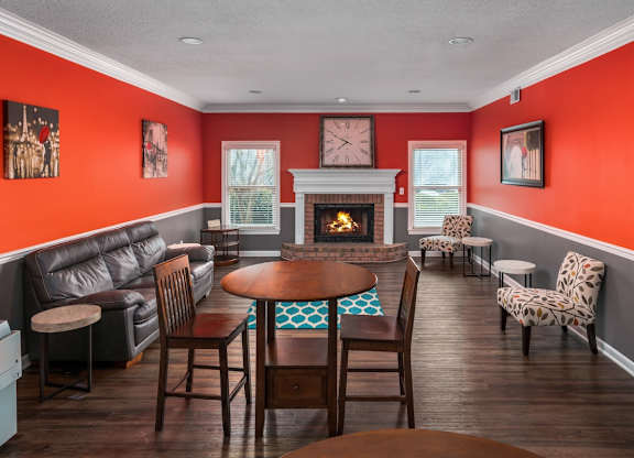 a living room with tables and chairs and a fireplace at Ascot Place Apartments, Alabama