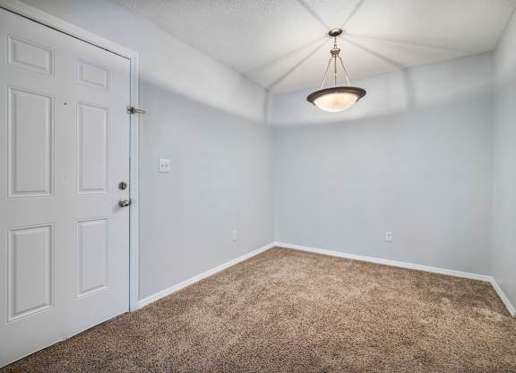 an empty room with carpet and a white door at Ascot Place Apartments, Birmingham Alabama