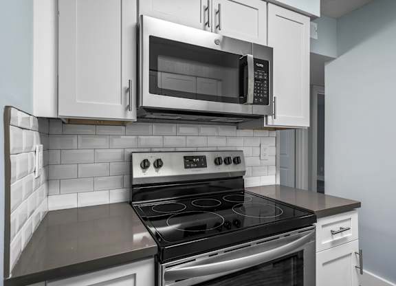a kitchen with a stove and a microwave at Ascot Place Apartments, Birmingham, AL
