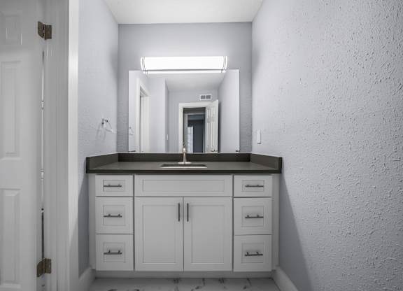 a white bathroom with a sink and a mirror at Ascot Place Apartments, Birmingham, AL 35235