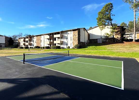 A tennis court is in front of a building.