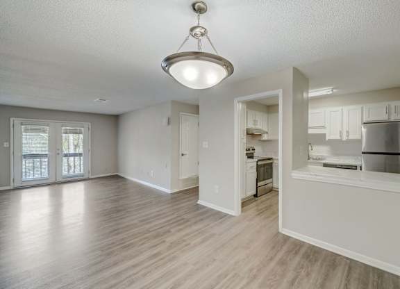 an empty living room and kitchen with an open floor plan
