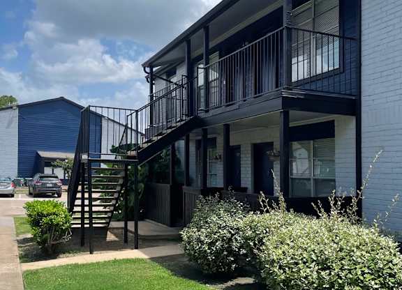 A modern house with a balcony and stairs leading to the second floor.