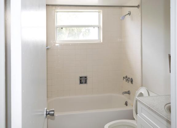 A white bathroom with a tub, toilet, and sink.