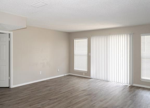 an empty living room with wood flooring and white walls