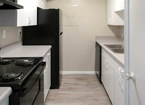 a kitchen with black appliances and white cabinets
