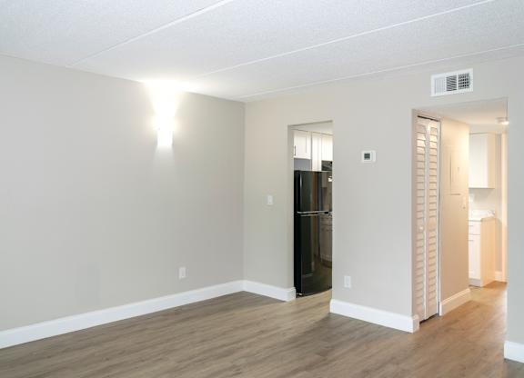 a living room with a wall sconce and an entrance to a hall and kitchen