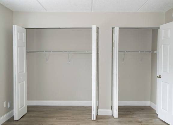 a Ridge Apartments bedroom with two large closets with hanging bars
